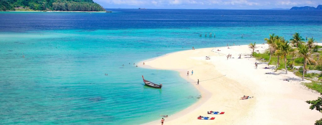 Tropical beachfront resort at sunset with hotel deals in Thailand